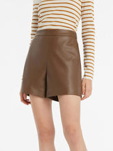 A lady wears leather shorts to a rock concert.